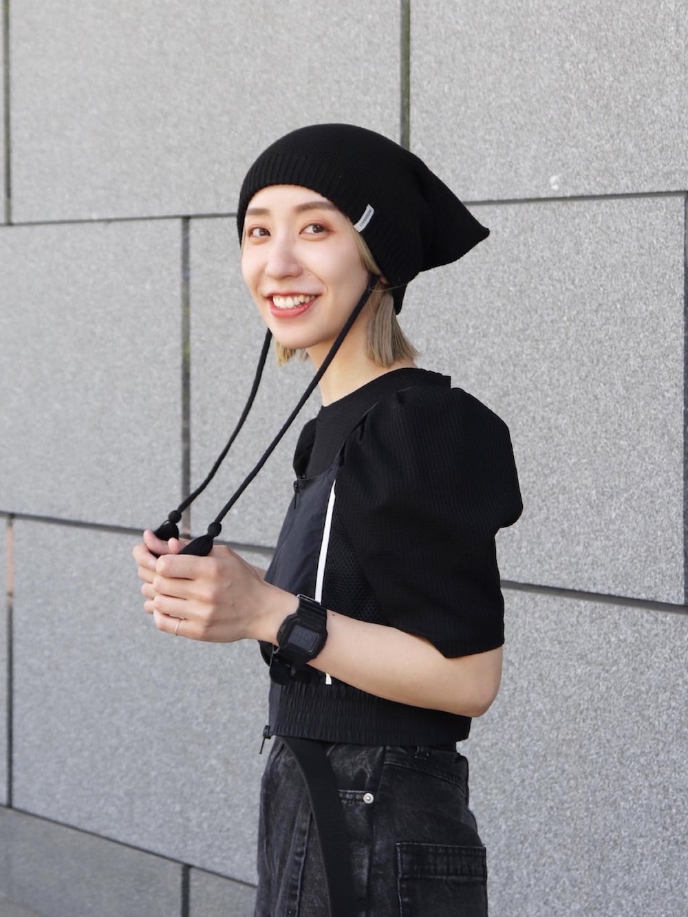 ブラック系のニットキャップ/ビーニーを着用したレディースの冬コーディネートの5枚目の写真
