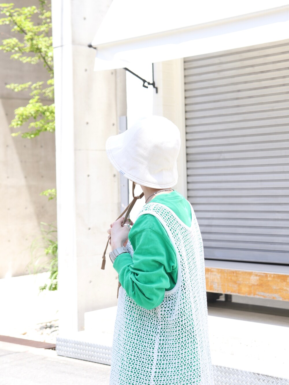 グレー系のスニーカー、ホワイト系のハットを着用したレディースの春コーディネートの2枚目の写真