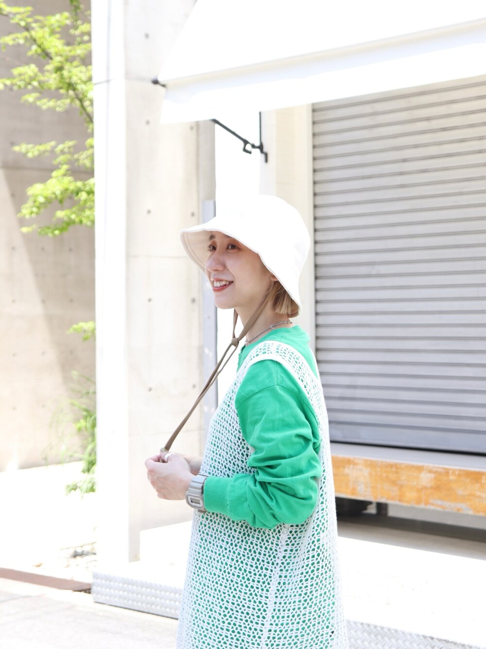 グレー系のスニーカー、ホワイト系のハットを着用したレディースの春コーディネートの3枚目の写真