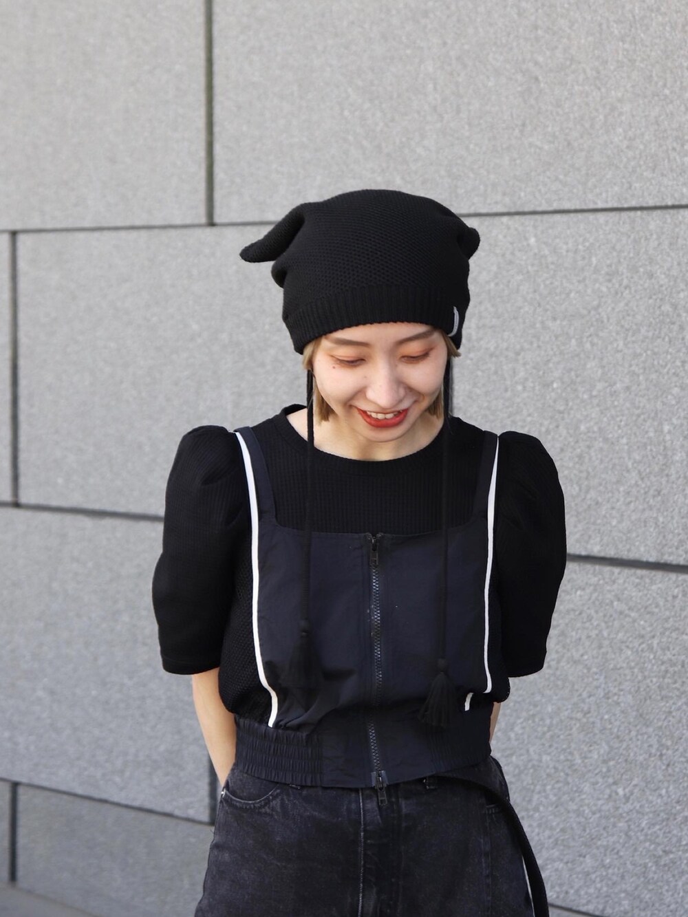 ブラック系のニットキャップ/ビーニーを着用したレディースの冬コーディネートの6枚目の写真