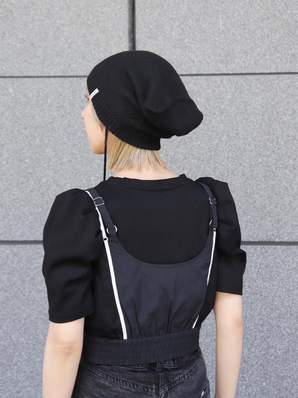 ブラック系のニットキャップ/ビーニーを着用したレディースの冬コーディネートの7枚目の写真