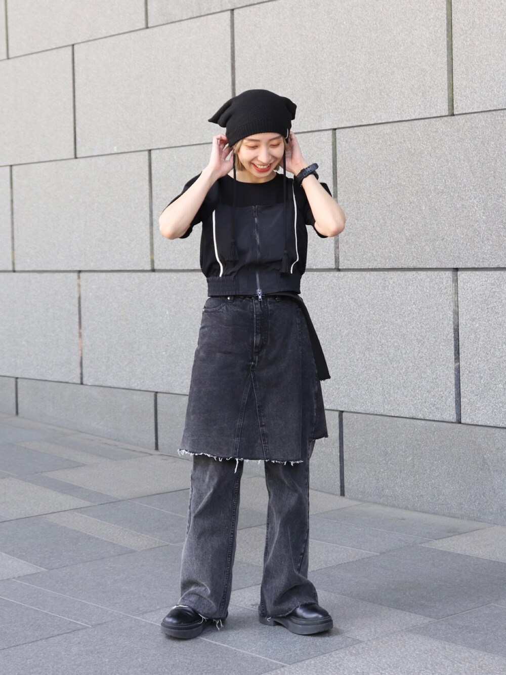 ブラック系のニットキャップ/ビーニーを着用したレディースの冬コーディネートの2枚目の写真