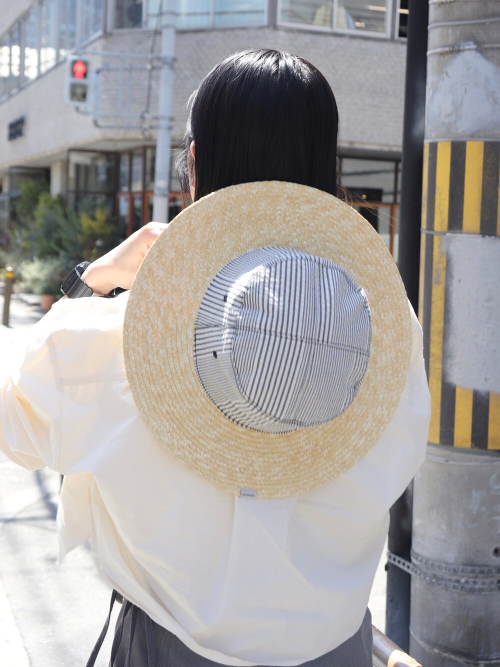 グレー系のその他パンツ、ホワイト系のシャツ/ブラウス、ブラック系のハットを着用したレディースの夏コーディネートの4枚目の写真