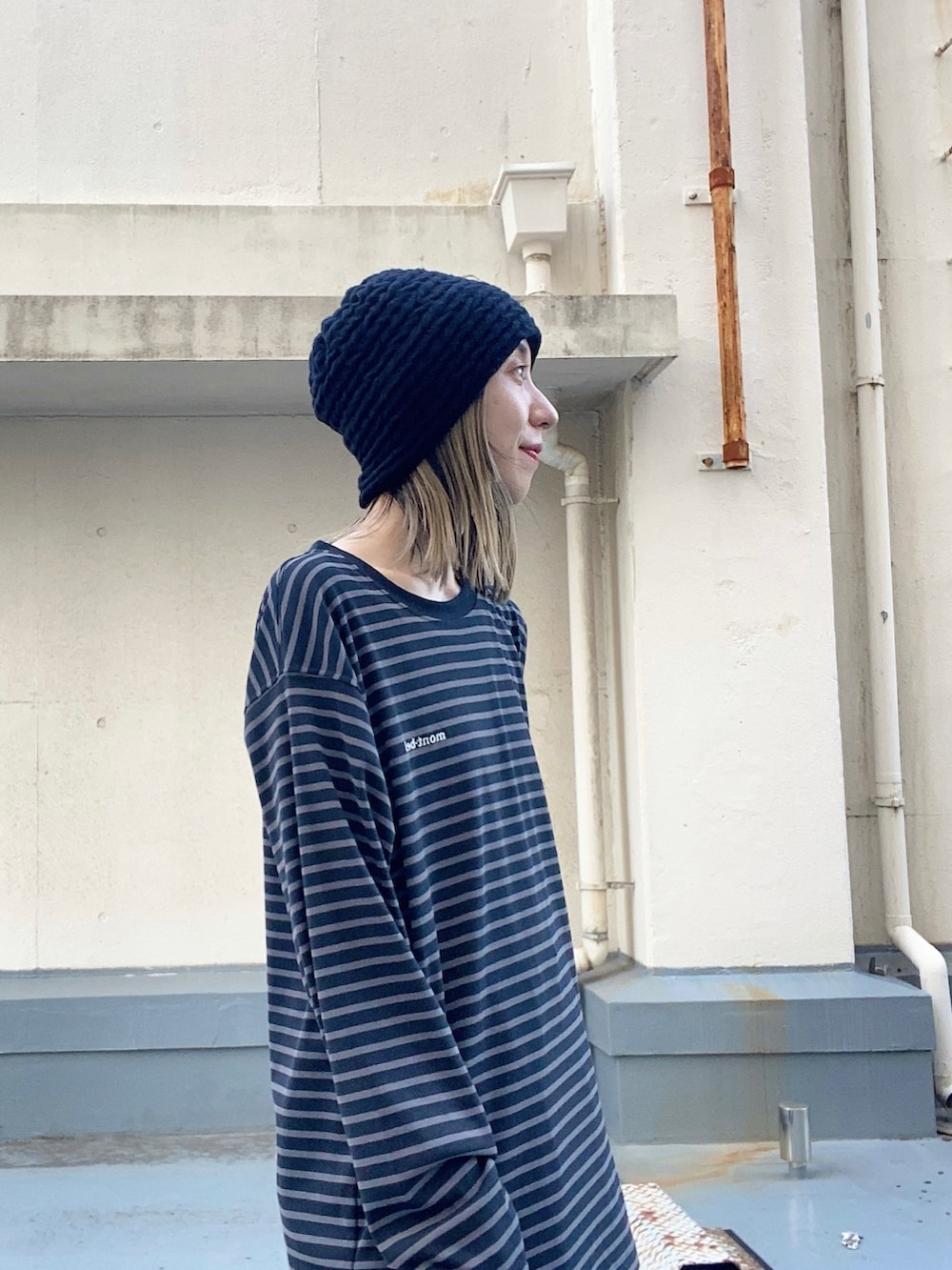 ブラック系のニットキャップ/ビーニーを着用したレディースの冬コーディネートの2枚目の写真