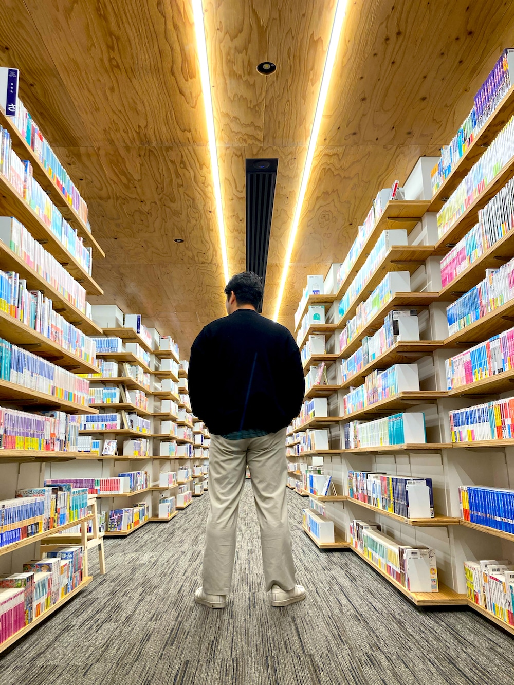 グリーン系のTシャツ/カットソー、ホワイト系のスニーカー、ブラック系のカーディガン/ボレロを着用したメンズの秋コーディネートの3枚目の写真