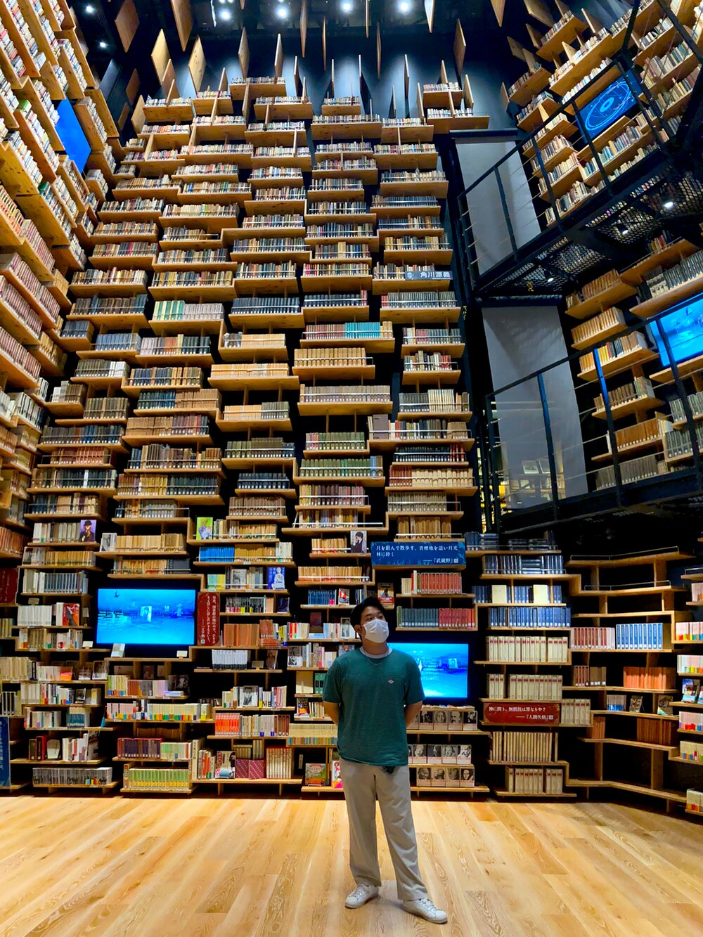 グリーン系のTシャツ/カットソー、ホワイト系のスニーカー、ブラック系のカーディガン/ボレロを着用したメンズの秋コーディネートの4枚目の写真