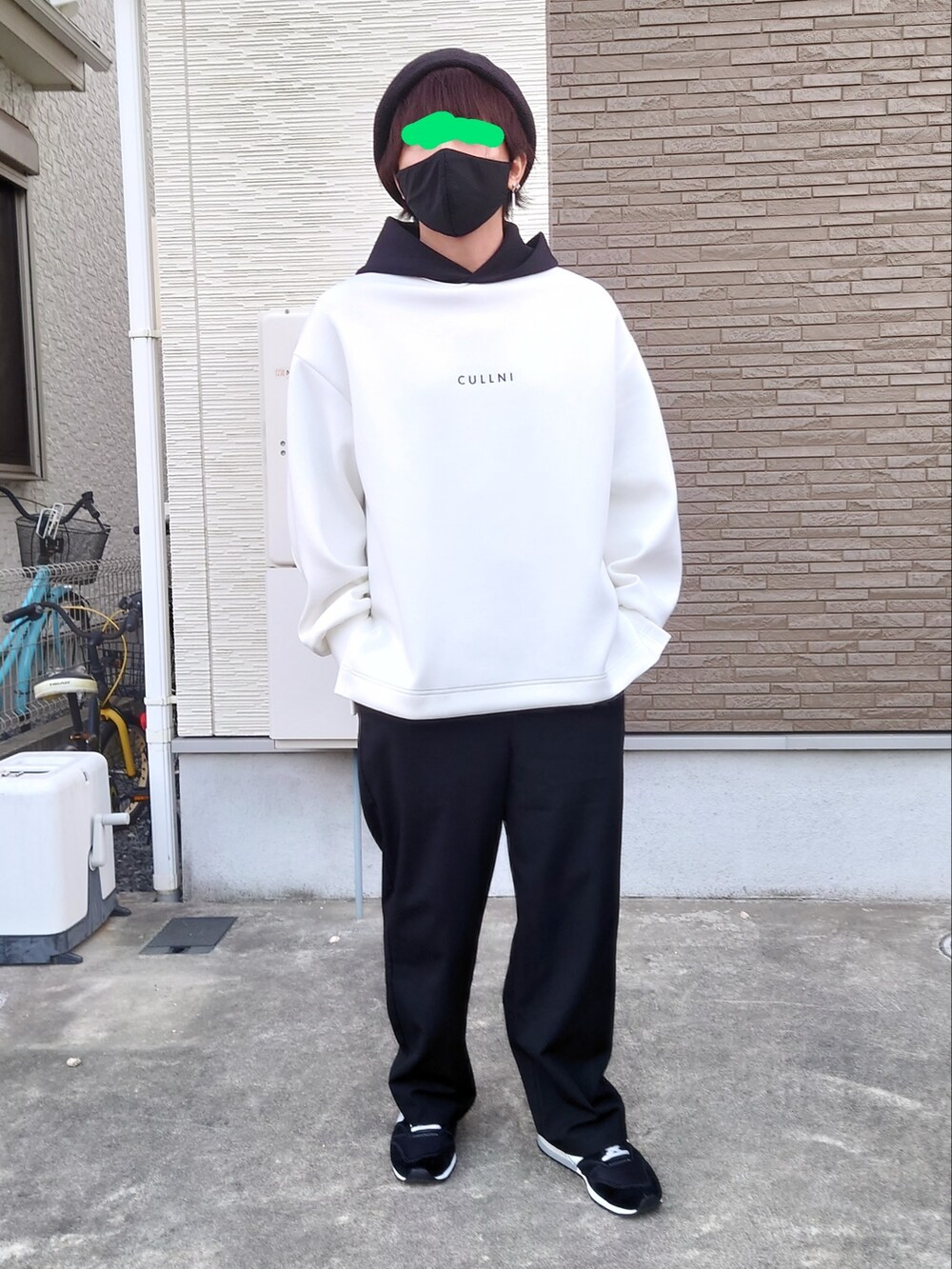 ホワイト系のパーカー、ブラック系のスニーカー、ブラック系のスラックスを着用したメンズの秋コーディネートの3枚目の写真