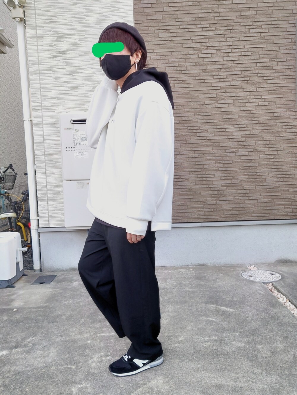 ホワイト系のパーカー、ブラック系のスニーカー、ブラック系のスラックスを着用したメンズの秋コーディネートの2枚目の写真