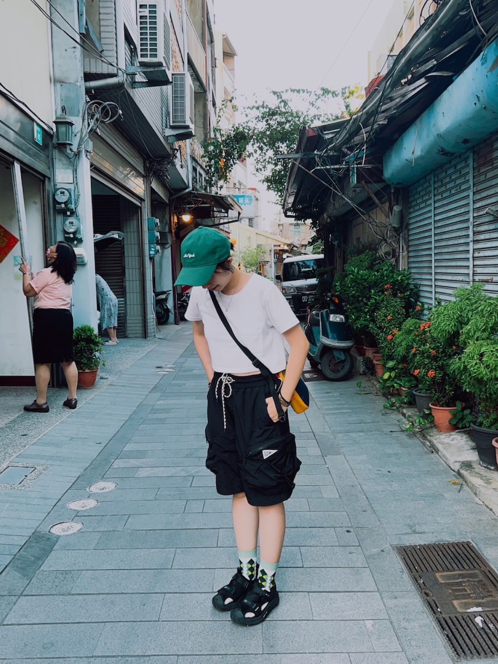 ブラック系のカーゴパンツ、グリーン系のキャップを着用したレディースの夏コーディネートの2枚目の写真