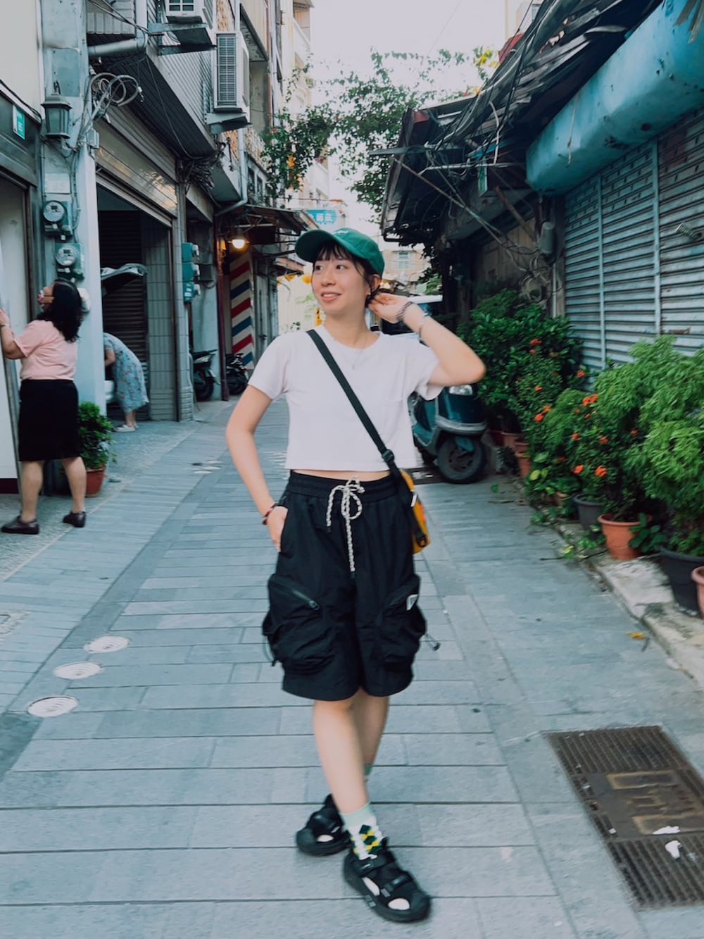 ブラック系のカーゴパンツ、グリーン系のキャップを着用したレディースの夏コーディネートの3枚目の写真