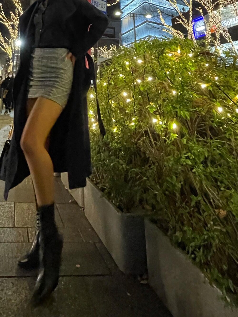 グレー系のスカート、ブラック系のシャツ/ブラウス、ブラック系のブーツを着用したレディースの冬コーディネートの2枚目の写真