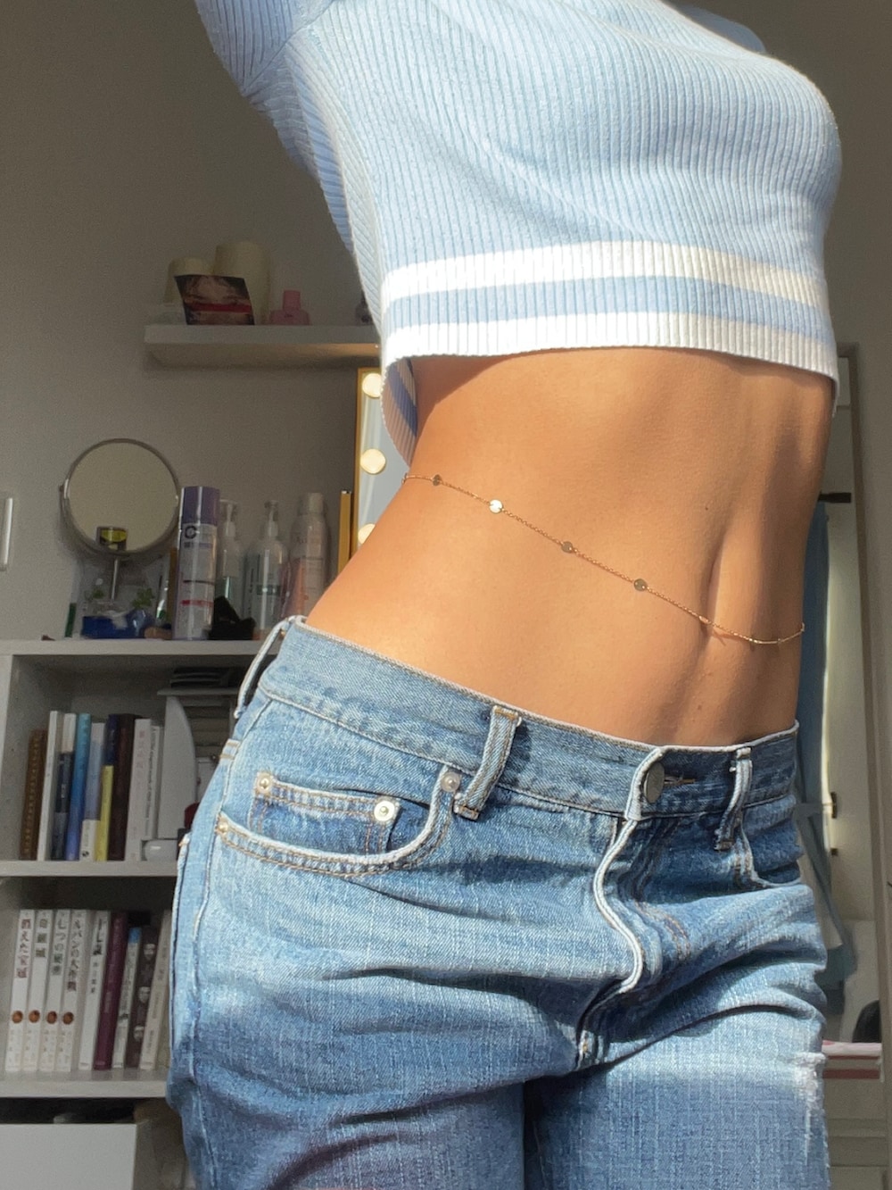 ブルー系のニット/セーター、ブルー系のデニムパンツ、ゴールド系のアクセサリーを着用したレディースの冬コーディネートの2枚目の写真