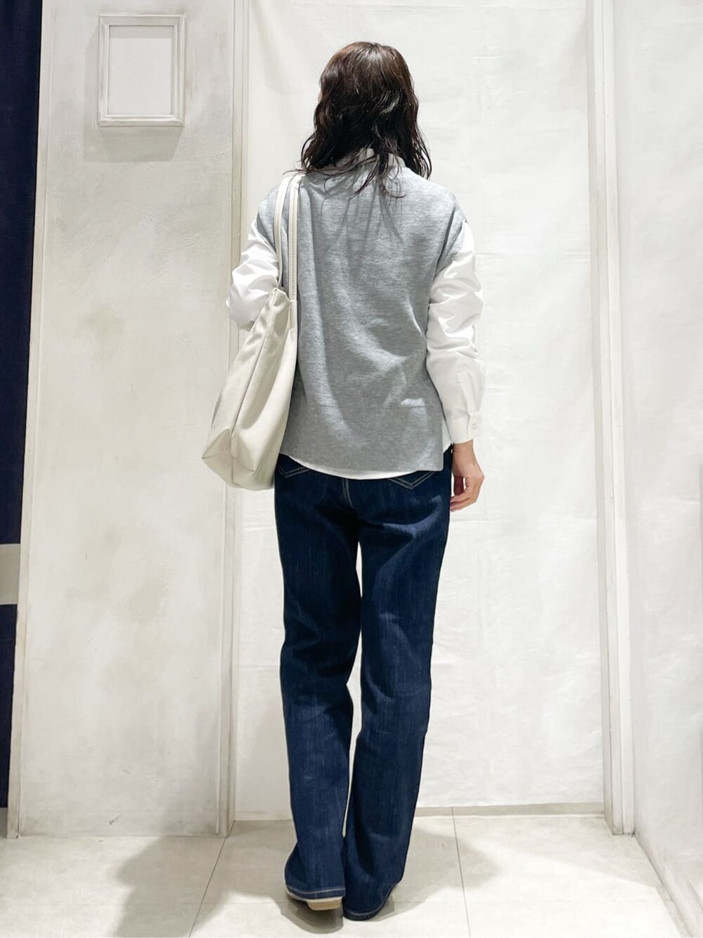 グレー系のシャツ/ブラウス、ブルー系のデニムパンツ、ベージュ系のトートバッグを着用したレディースの冬コーディネートの3枚目の写真