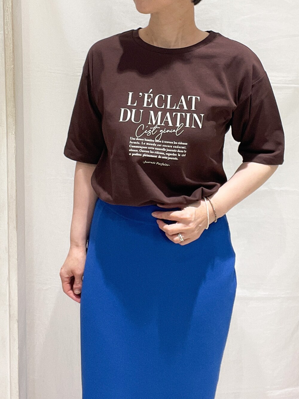 ベージュ系のブルゾン、ブラウン系のTシャツ/カットソー、ブルー系のスカートを着用したレディースの春コーディネートの5枚目の写真