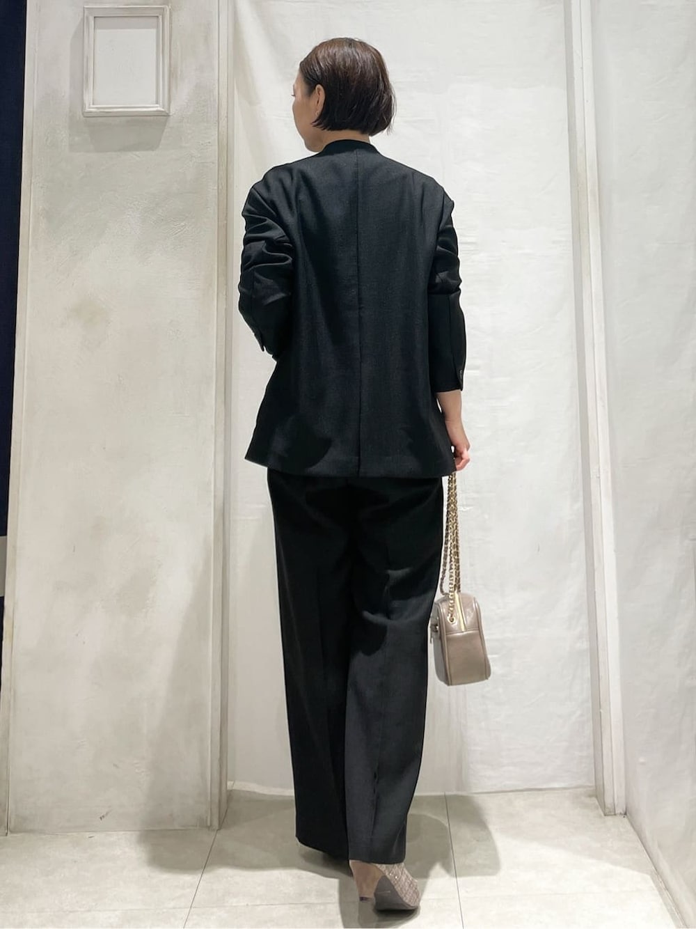 ブラウン系のパンプス、グレー系のショルダーバッグ、ブラック系のノーカラージャケットを着用したレディースの春コーディネートの4枚目の写真