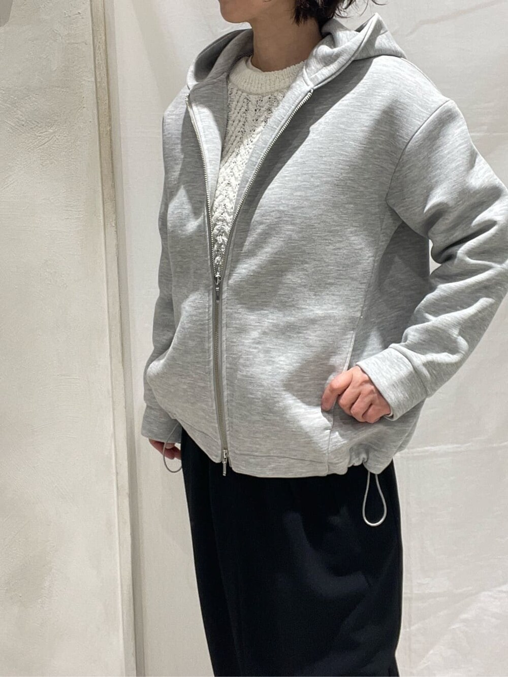 グレー系のブルゾン、ホワイト系のニット/セーター、ホワイト系のTシャツ/カットソーを着用したレディースの冬コーディネートの7枚目の写真