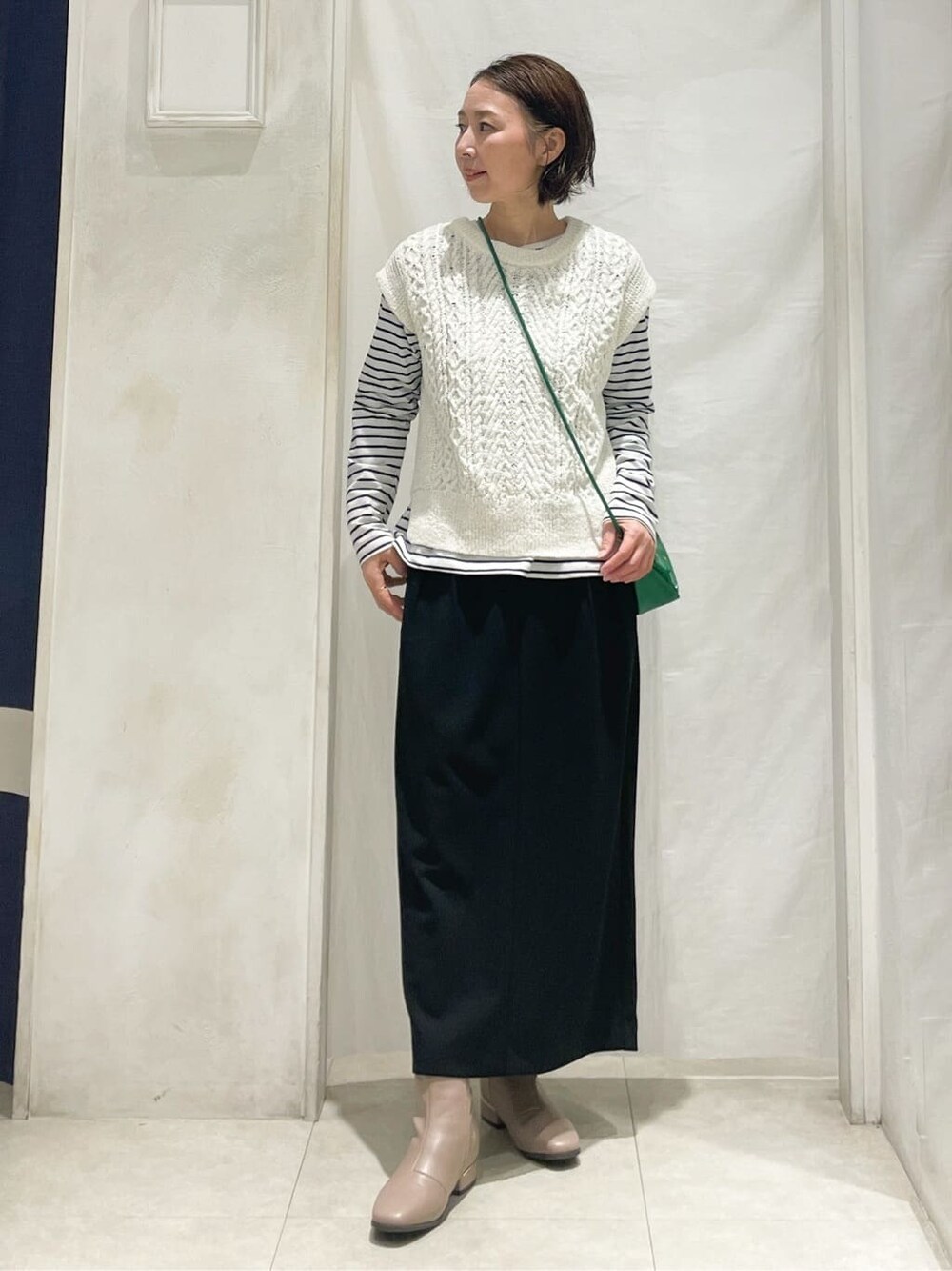 グレー系のブルゾン、ホワイト系のニット/セーター、ホワイト系のTシャツ/カットソーを着用したレディースの冬コーディネートの5枚目の写真
