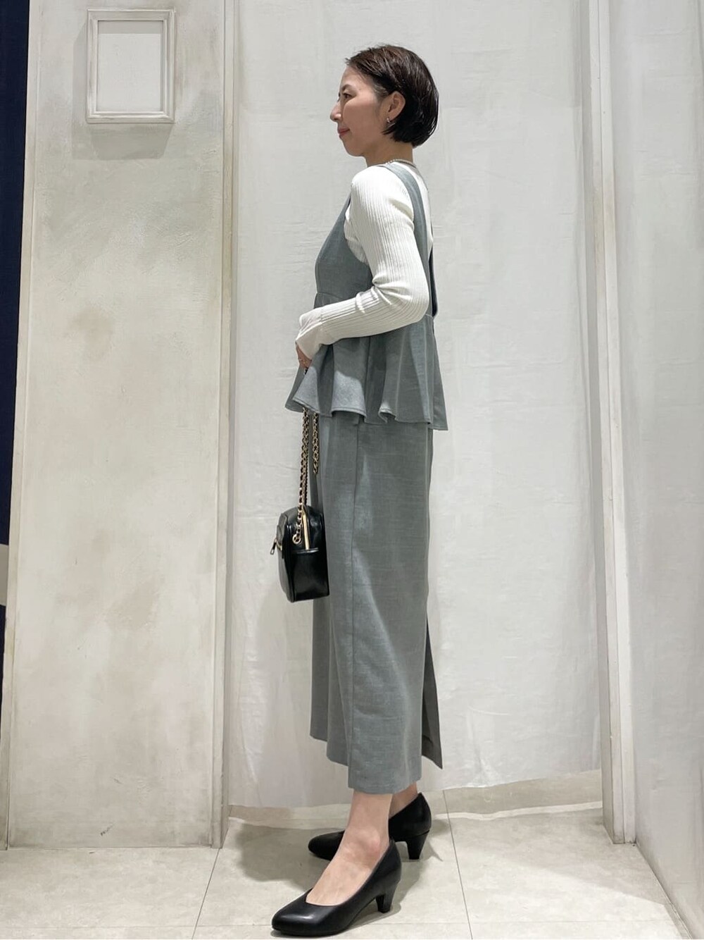 ブルー系のシャツ/ブラウス、ブラック系のパンプス、ブラック系のショルダーバッグを着用したレディースの春コーディネートの3枚目の写真