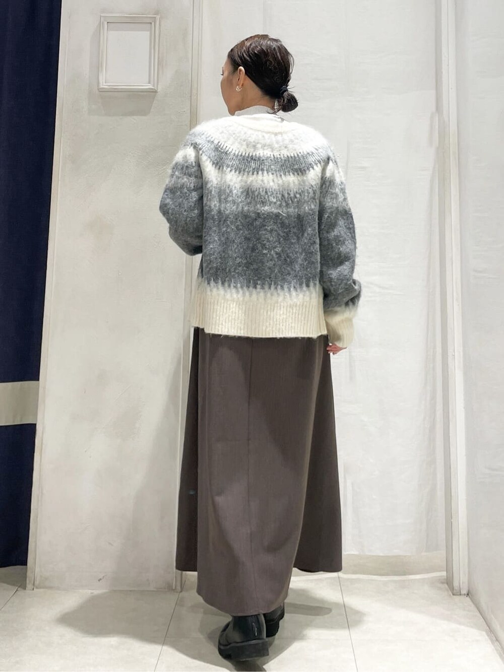 ブラック系のカーディガン/ボレロ、ブラウン系のワンピースを着用したレディースの冬コーディネートの4枚目の写真