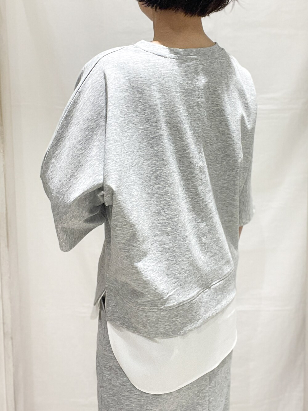 グレー系のセットアップ、レッド系のカーディガン/ボレロ、ブラック系のトートバッグを着用したレディースの春コーディネートの6枚目の写真