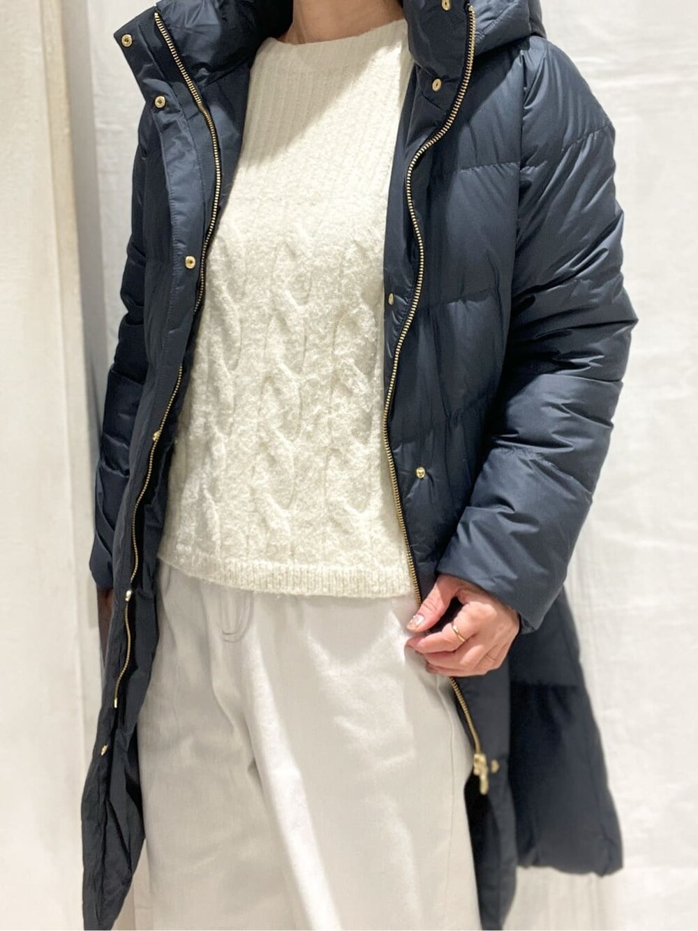 ブルー系のダウンジャケット/コート、ホワイト系のニット/セーター、ホワイト系のその他パンツを着用したレディースの冬コーディネートの5枚目の写真