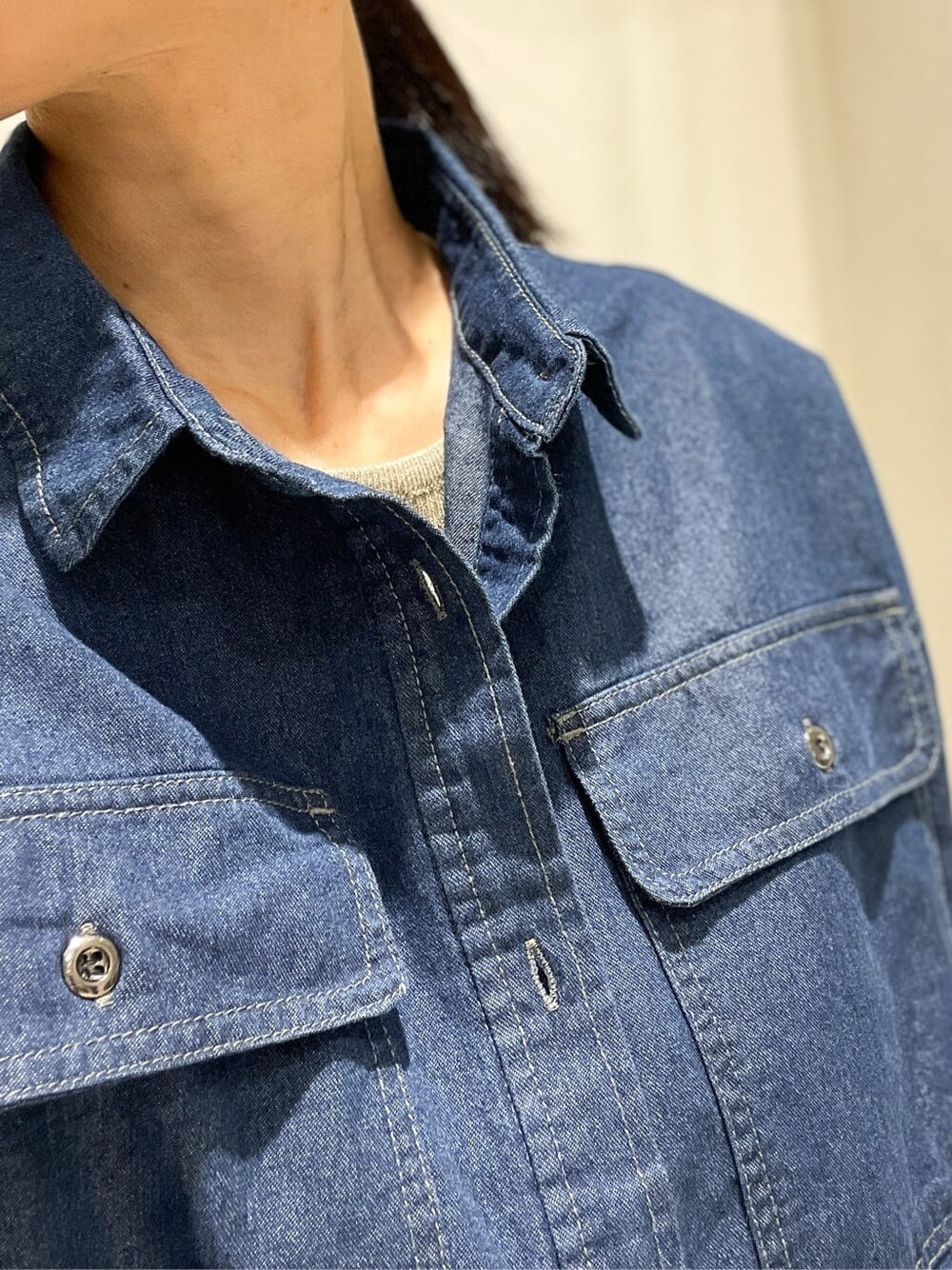 ブルー系のシャツ/ブラウス、ベージュ系のタンクトップ、ブラック系のスカートを着用したレディースの秋コーディネートの5枚目の写真