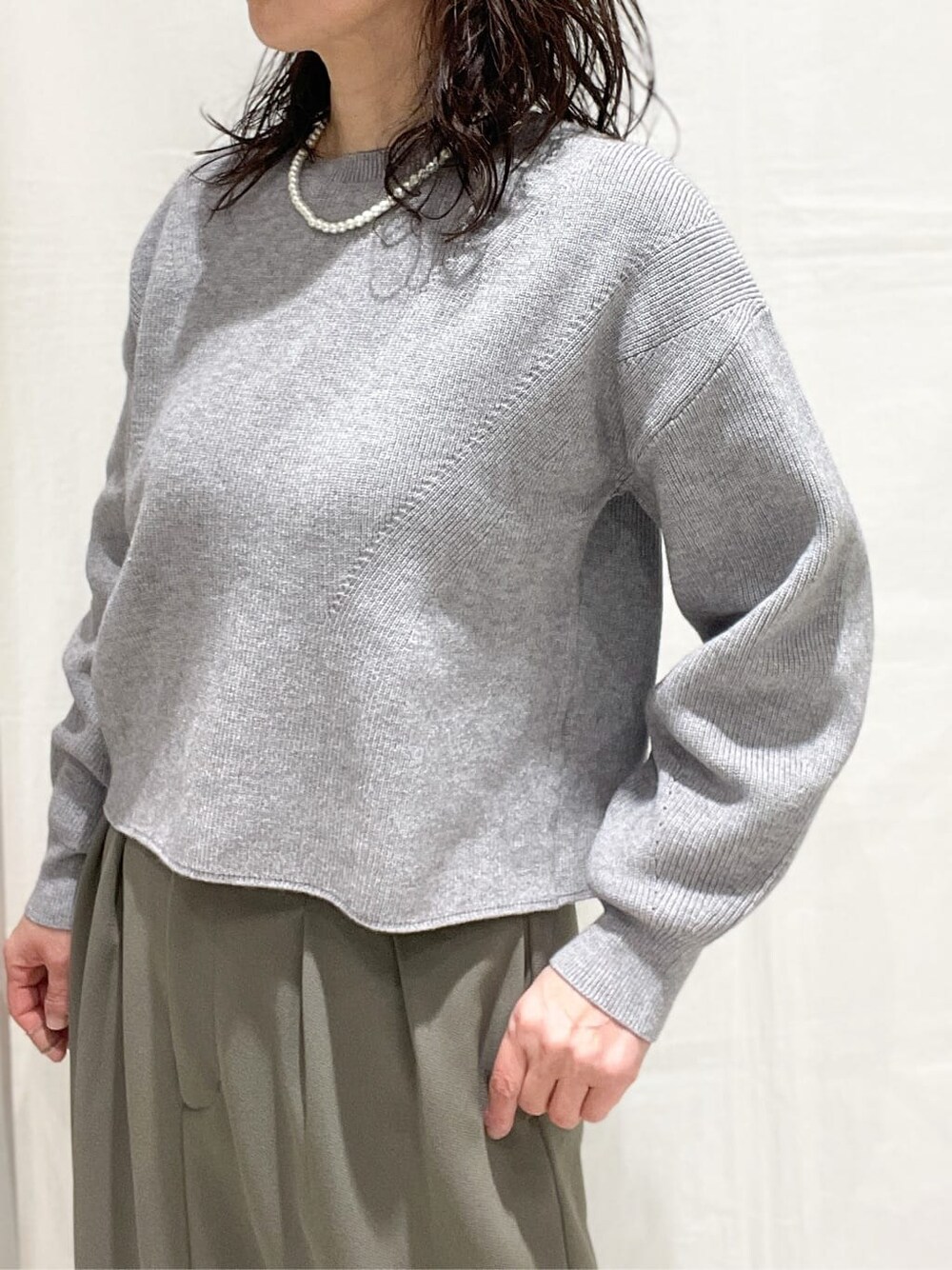 ブルー系のデニムジャケット、グレー系のニット/セーター、ブラウン系のスカートを着用したレディースの冬コーディネートの6枚目の写真