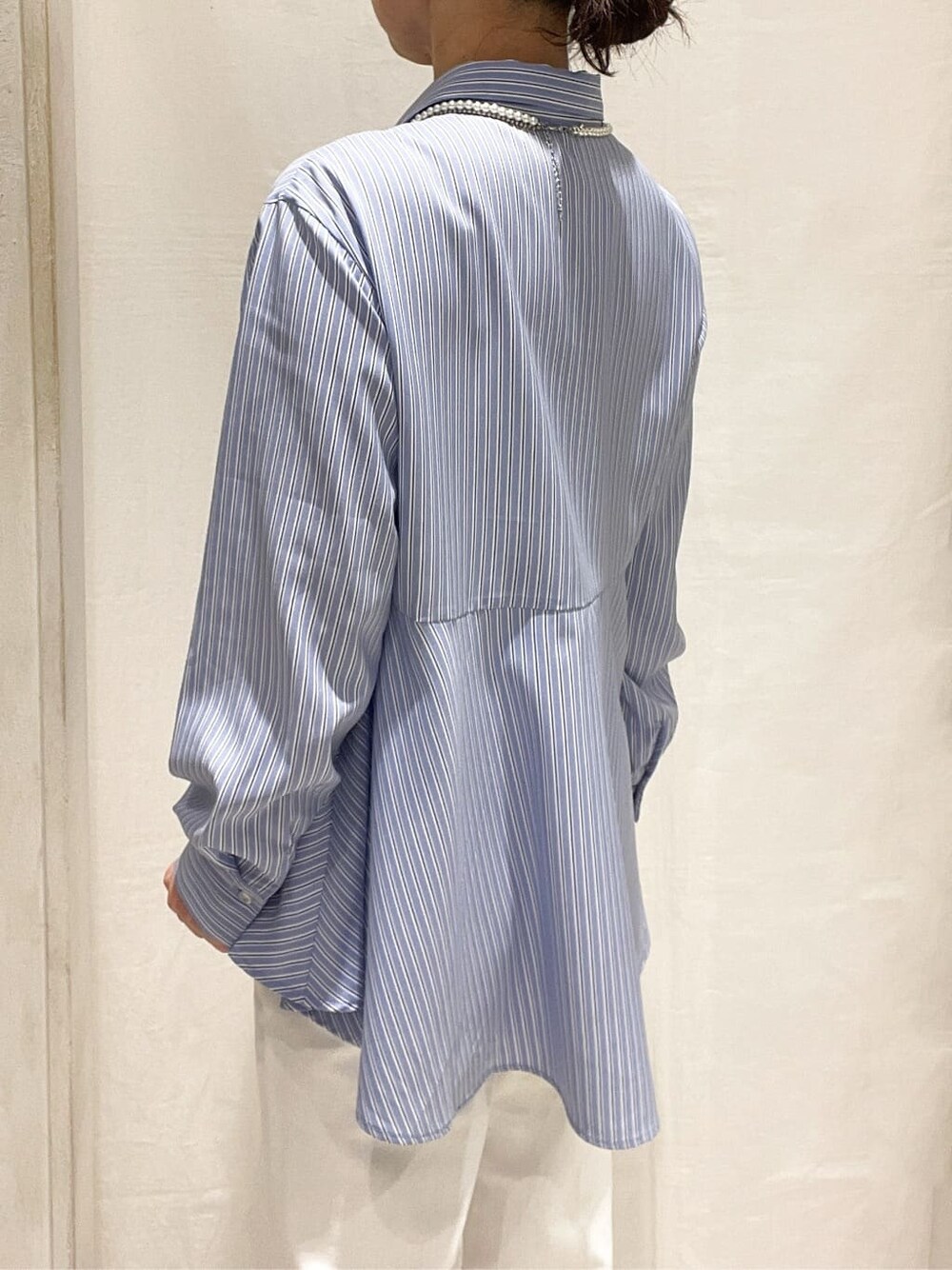 ブルー系のカーディガン/ボレロ、ブルー系のシャツ/ブラウス、ホワイト系のデニムパンツを着用したレディースの冬コーディネートの5枚目の写真