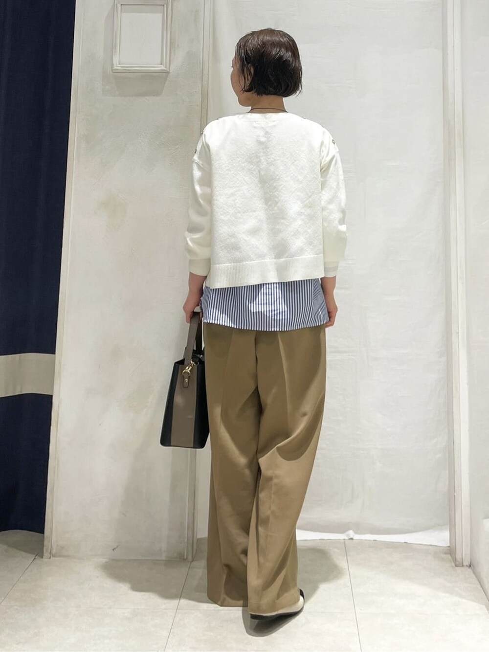 ホワイト系のニット/セーター、ブルー系のTシャツ/カットソー、ブラウン系のその他パンツを着用したレディースの春コーディネートの3枚目の写真