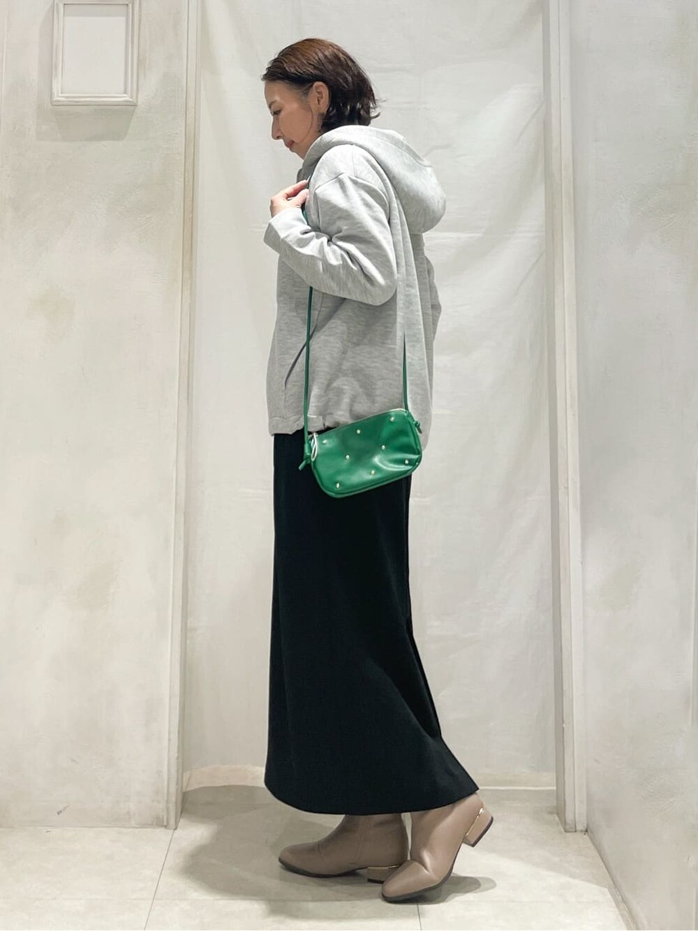 グレー系のブルゾン、ホワイト系のニット/セーター、ホワイト系のTシャツ/カットソーを着用したレディースの冬コーディネートの2枚目の写真