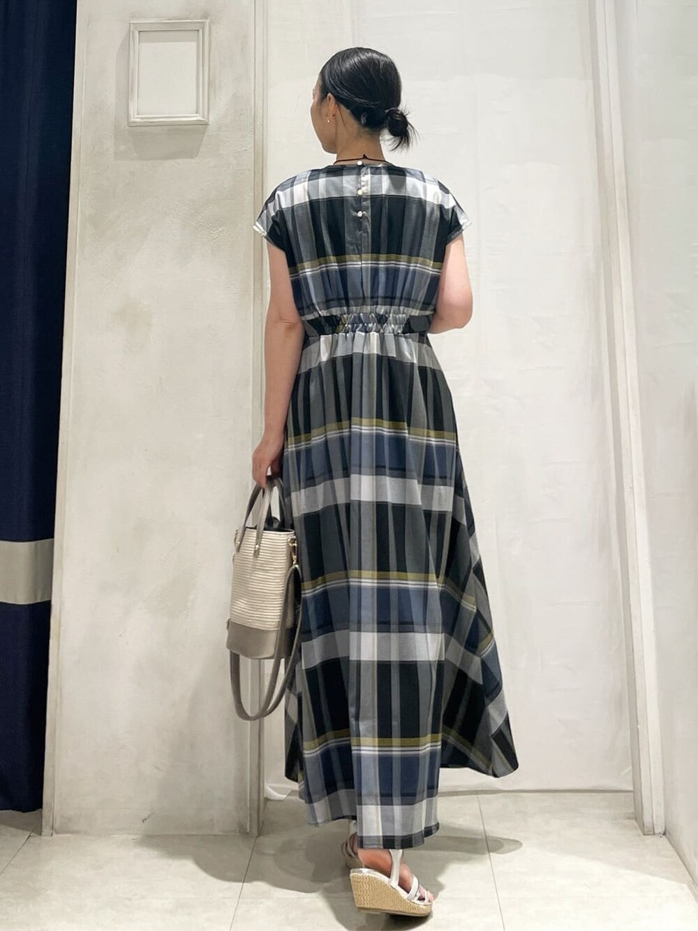 シルバー系のトートバッグ、ゴールド系のイヤリング、ゴールド系のネックレスを着用したレディースの夏コーディネートの4枚目の写真