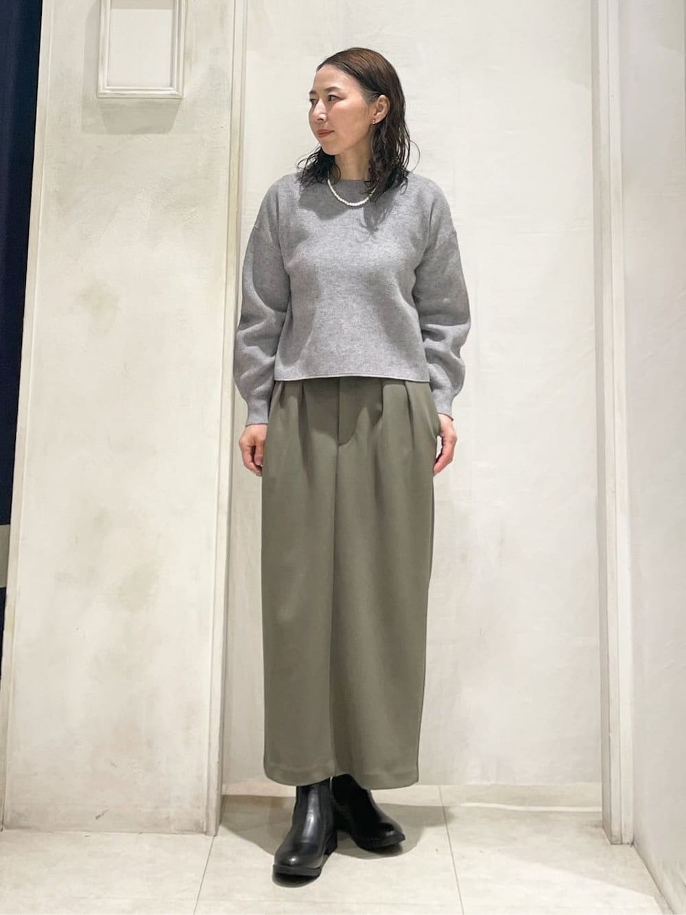 ブルー系のデニムジャケット、グレー系のニット/セーター、ブラウン系のスカートを着用したレディースの冬コーディネートの2枚目の写真