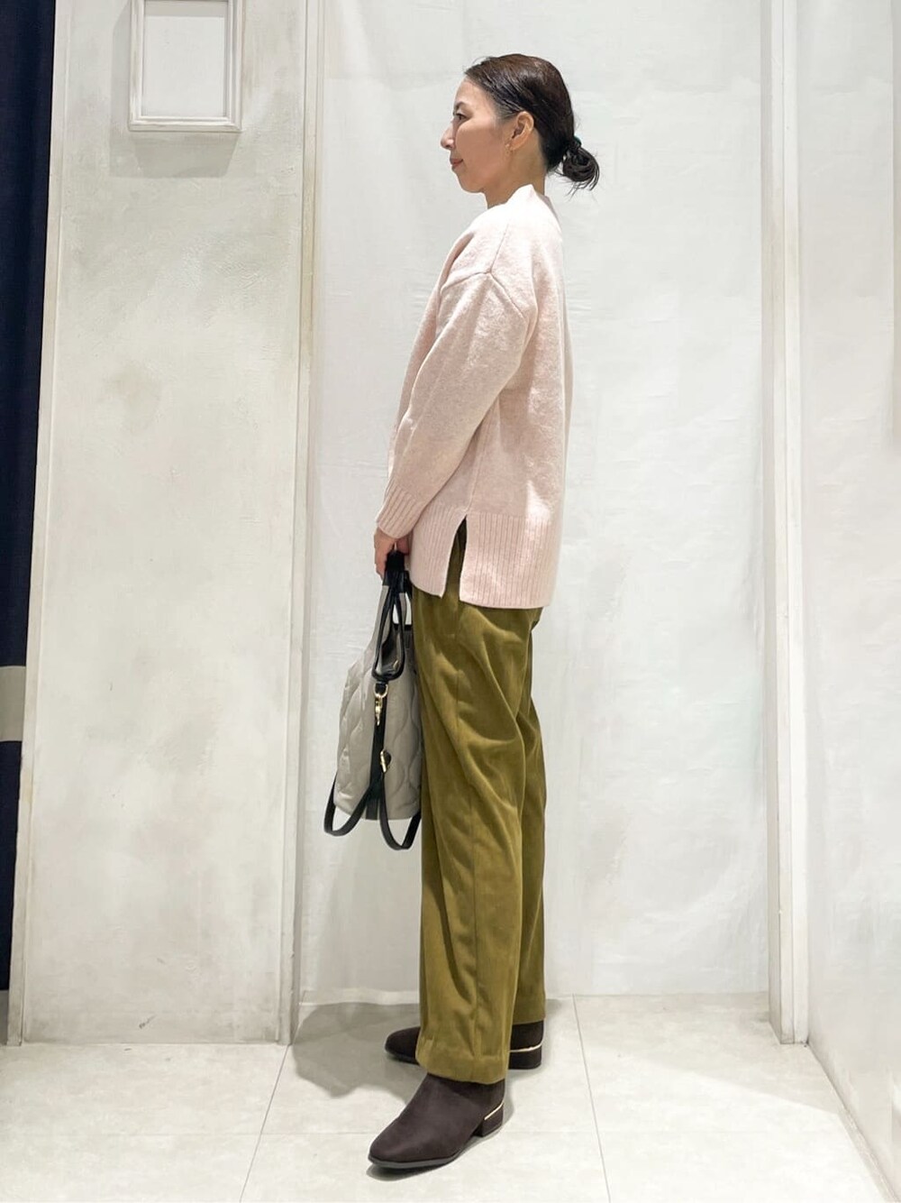 ピンク系のニット/セーター、イエロー系のその他パンツ、ベージュ系のトートバッグを着用したレディースの秋コーディネートの2枚目の写真