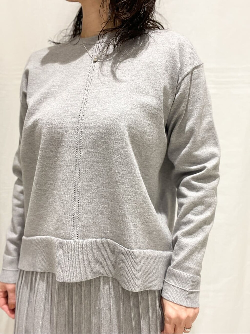 ブルー系のノーカラーコート、グレー系のニット/セーター、グレー系のスカートを着用したレディースの冬コーディネートの7枚目の写真