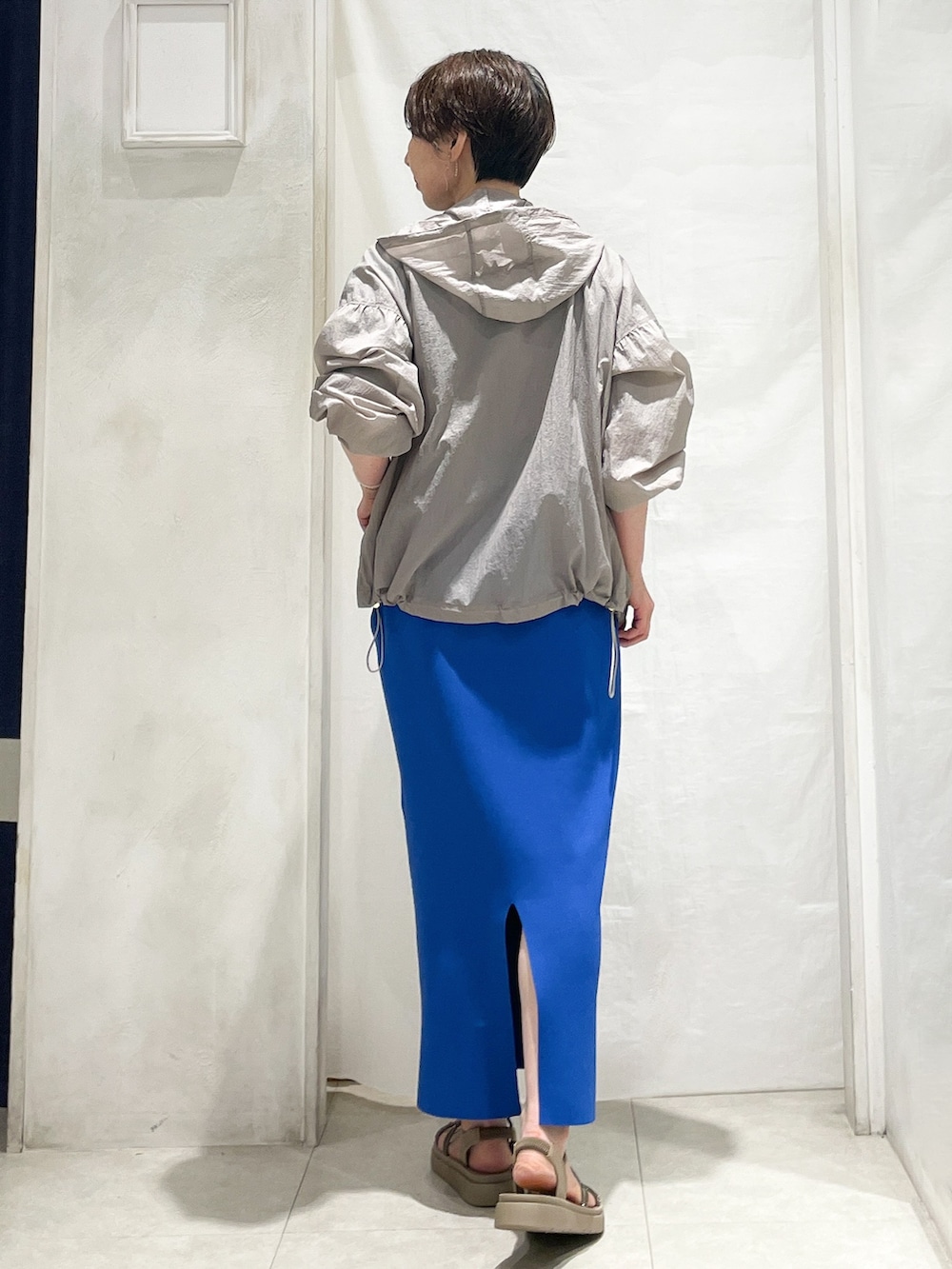 ベージュ系のブルゾン、ブラウン系のTシャツ/カットソー、ブルー系のスカートを着用したレディースの春コーディネートの3枚目の写真