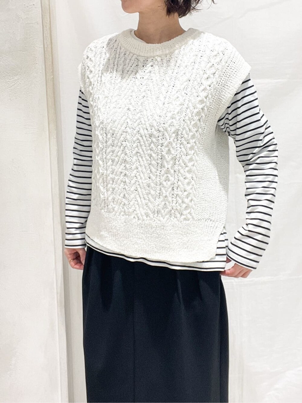 グレー系のブルゾン、ホワイト系のニット/セーター、ホワイト系のTシャツ/カットソーを着用したレディースの冬コーディネートの8枚目の写真