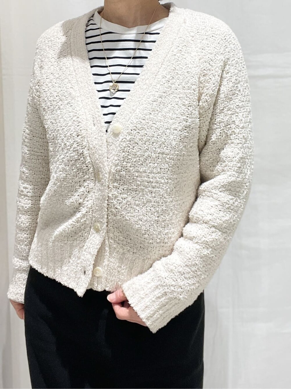 ホワイト系のカーディガン/ボレロ、ホワイト系のTシャツ/カットソー、ブラック系のスカートを着用したレディースの春コーディネートの4枚目の写真