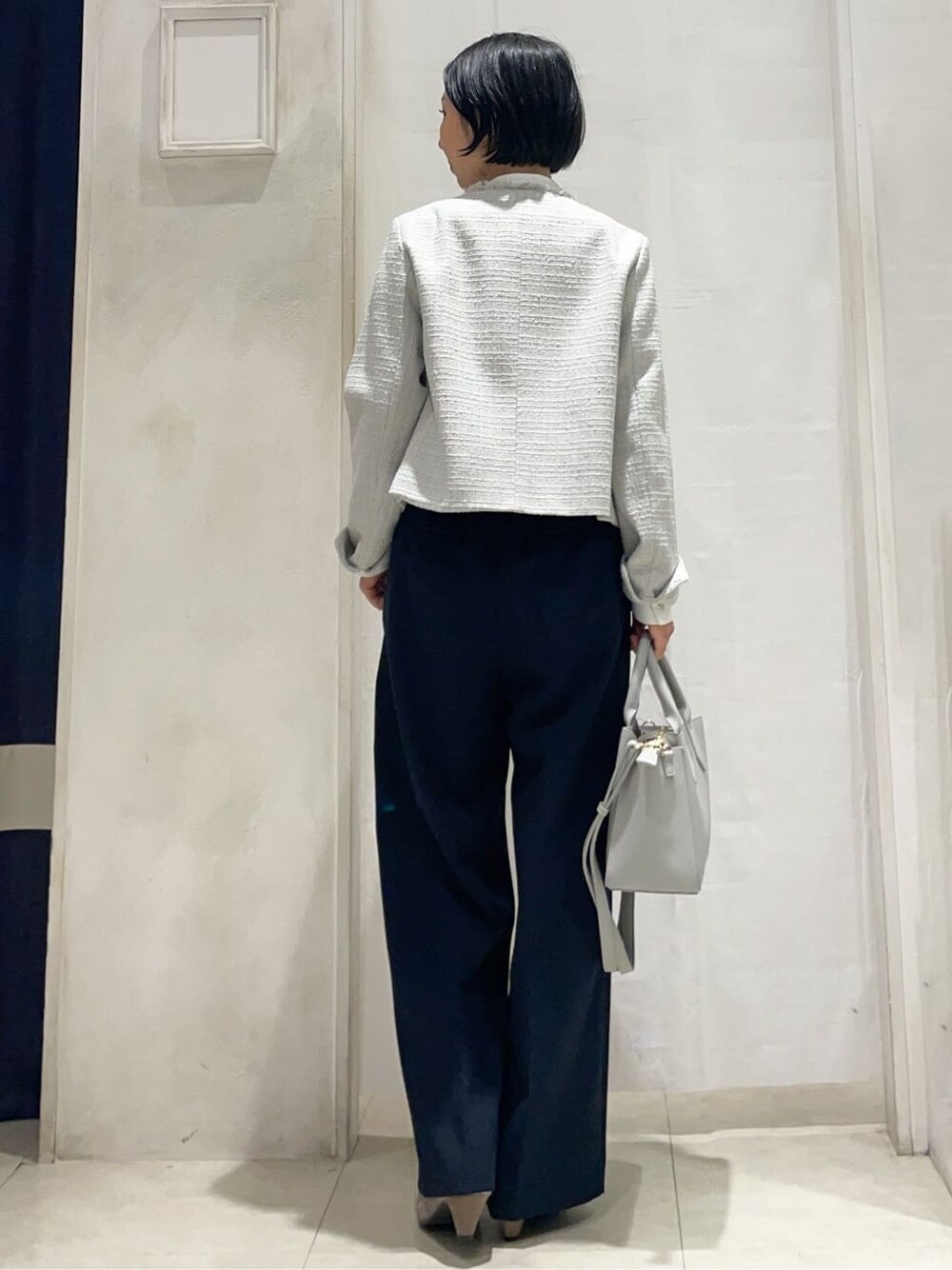 グレー系のノーカラージャケット、ホワイト系のシャツ/ブラウス、ブルー系のその他パンツを着用したレディースの冬コーディネートの3枚目の写真