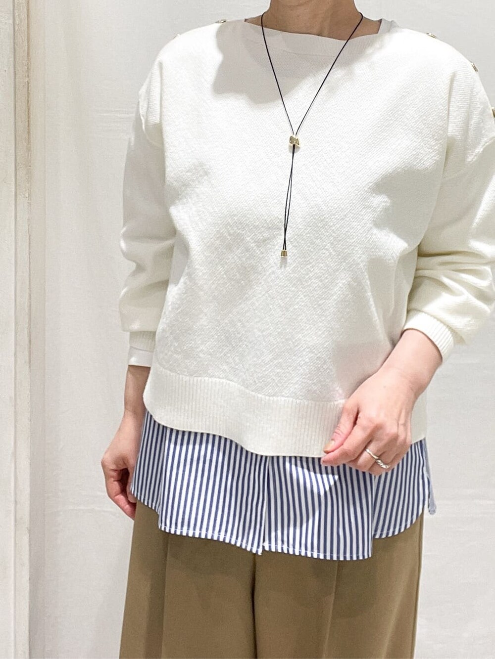ホワイト系のニット/セーター、ブルー系のTシャツ/カットソー、ブラウン系のその他パンツを着用したレディースの春コーディネートの4枚目の写真