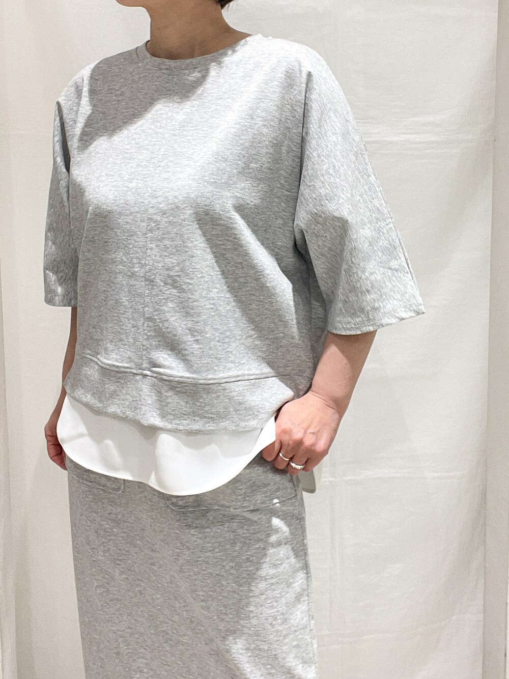 グレー系のセットアップ、レッド系のカーディガン/ボレロ、ブラック系のトートバッグを着用したレディースの春コーディネートの5枚目の写真