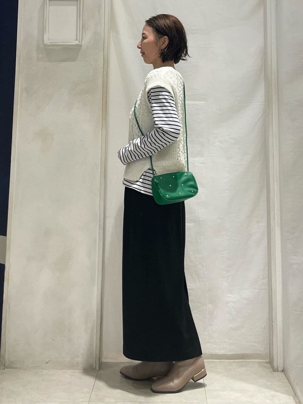 グレー系のブルゾン、ホワイト系のニット/セーター、ホワイト系のTシャツ/カットソーを着用したレディースの冬コーディネートの6枚目の写真