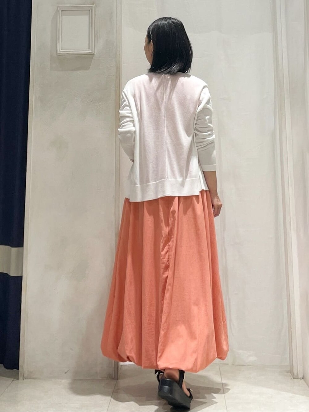 ホワイト系のカーディガン/ボレロ、オレンジ系のワンピース、その他のネックレスを着用したレディースの夏コーディネートの5枚目の写真