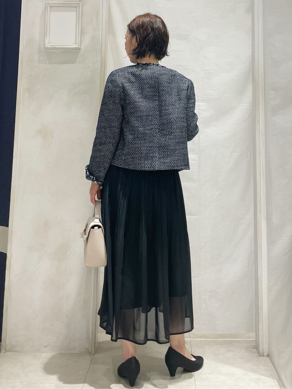 ブルー系のノーカラージャケット、ブラック系のワンピース、ベージュ系のショルダーバッグを着用したレディースの冬コーディネートの3枚目の写真