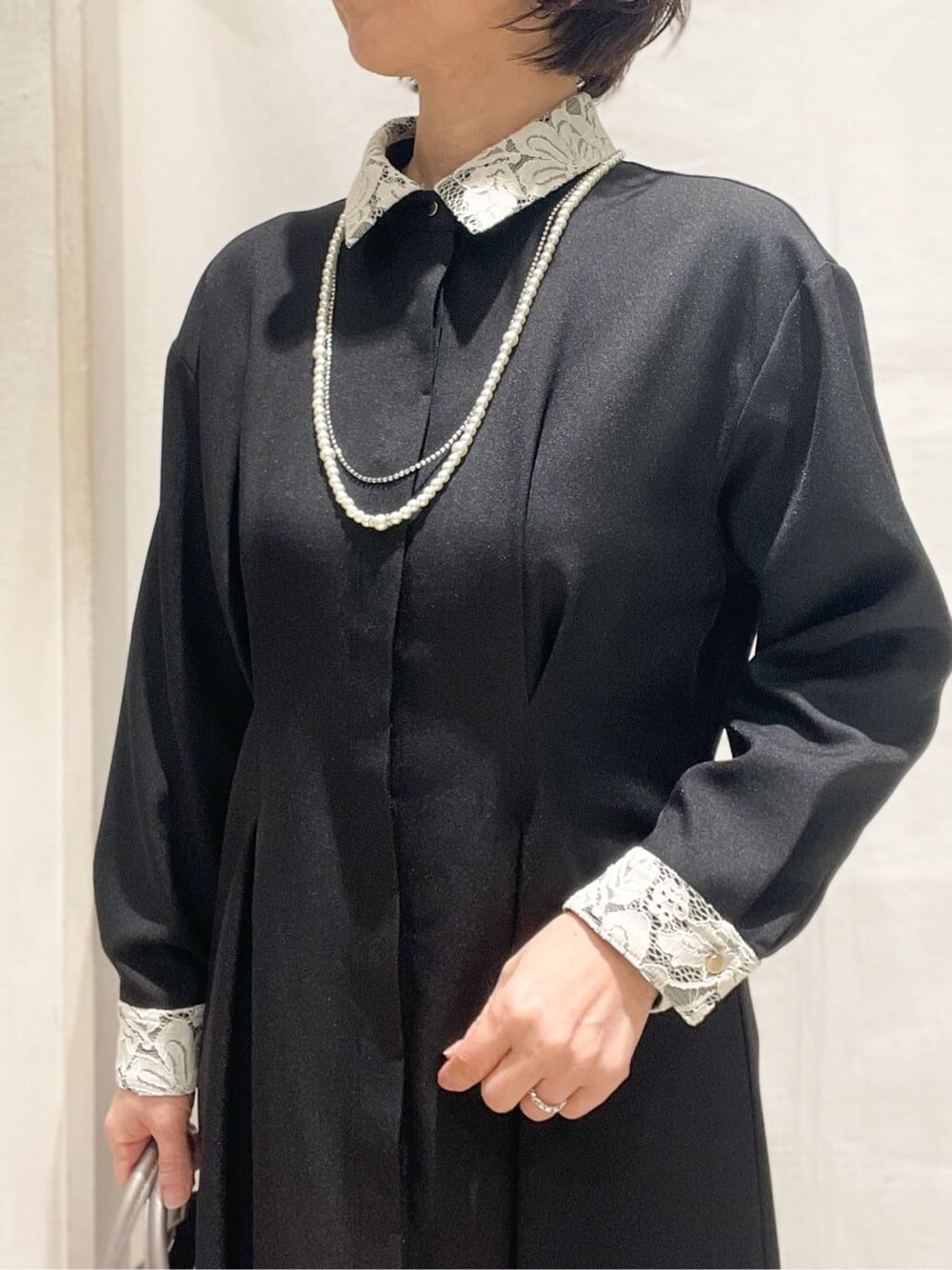 ブラック系のワンピース、シルバー系のトートバッグ、ブラック系のパンプスを着用したレディースの冬コーディネートの4枚目の写真