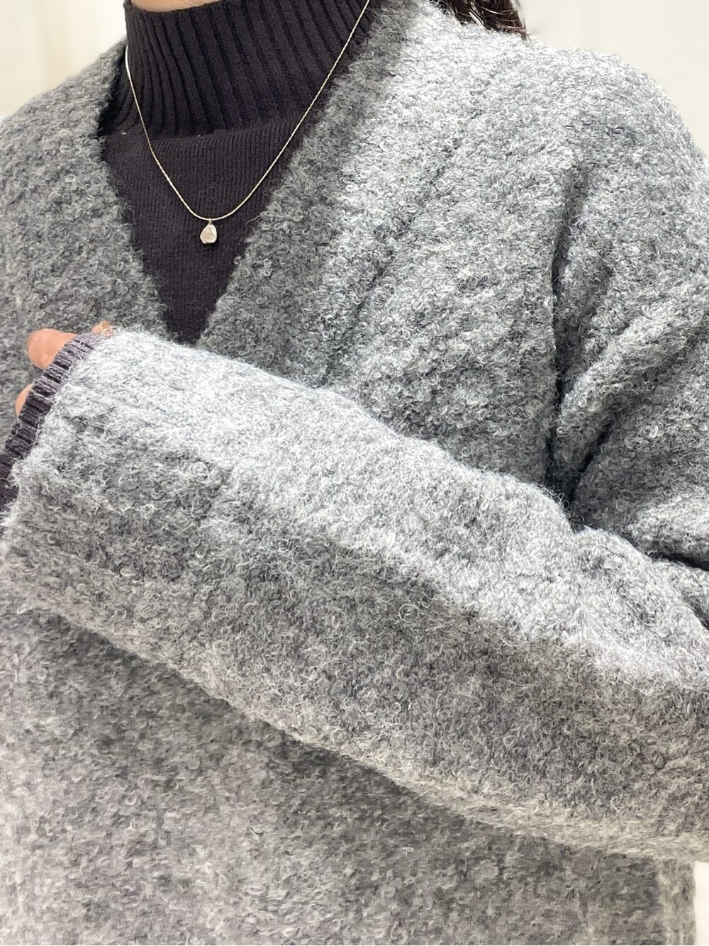 グレー系のワンピース、ベージュ系のトートバッグ、ゴールド系のネックレスを着用したレディースの冬コーディネートの5枚目の写真