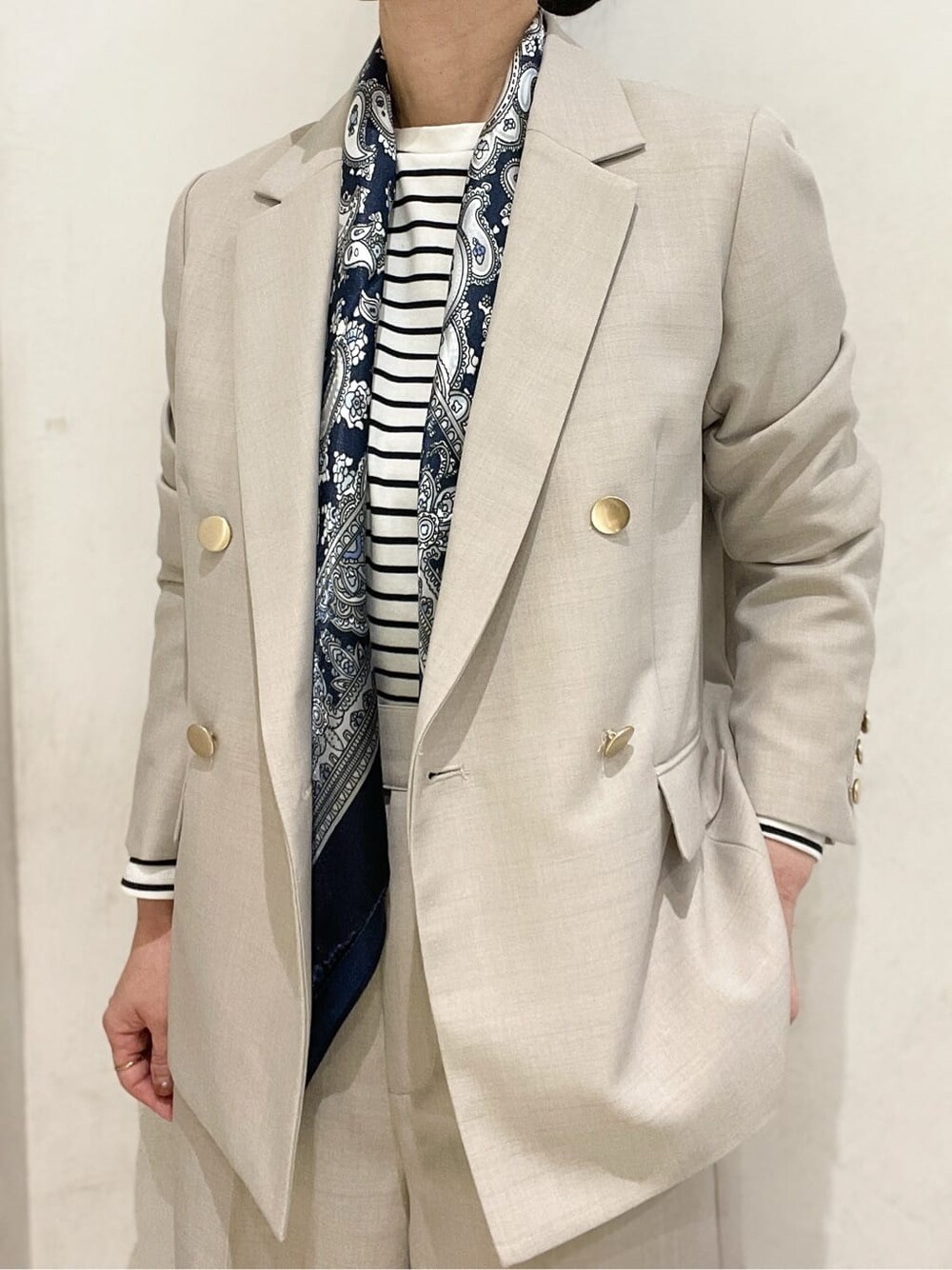 ベージュ系のテーラードジャケット、ホワイト系のTシャツ/カットソー、ベージュ系のその他パンツを着用したレディースの秋コーディネートの4枚目の写真