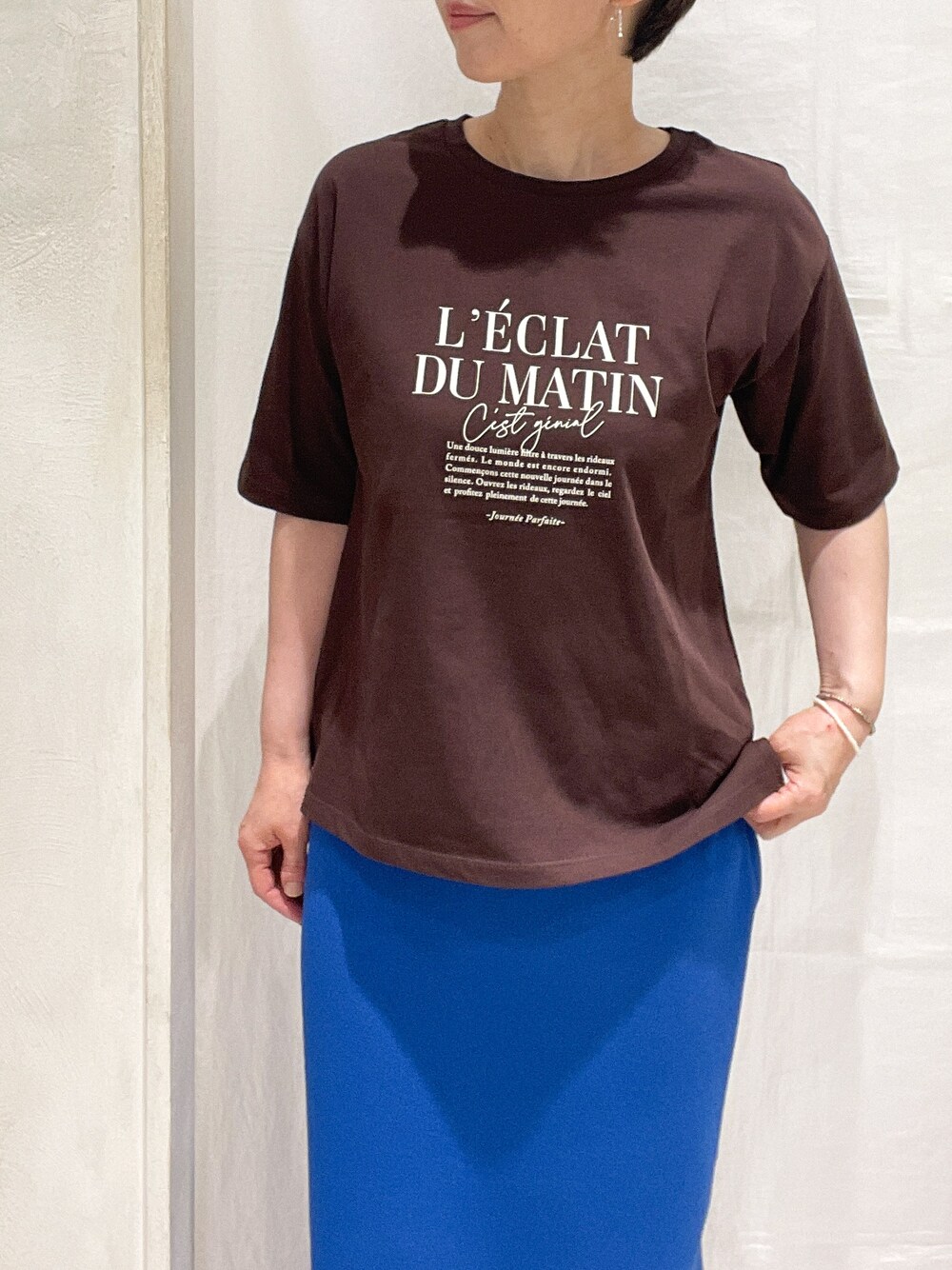 ベージュ系のブルゾン、ブラウン系のTシャツ/カットソー、ブルー系のスカートを着用したレディースの春コーディネートの6枚目の写真