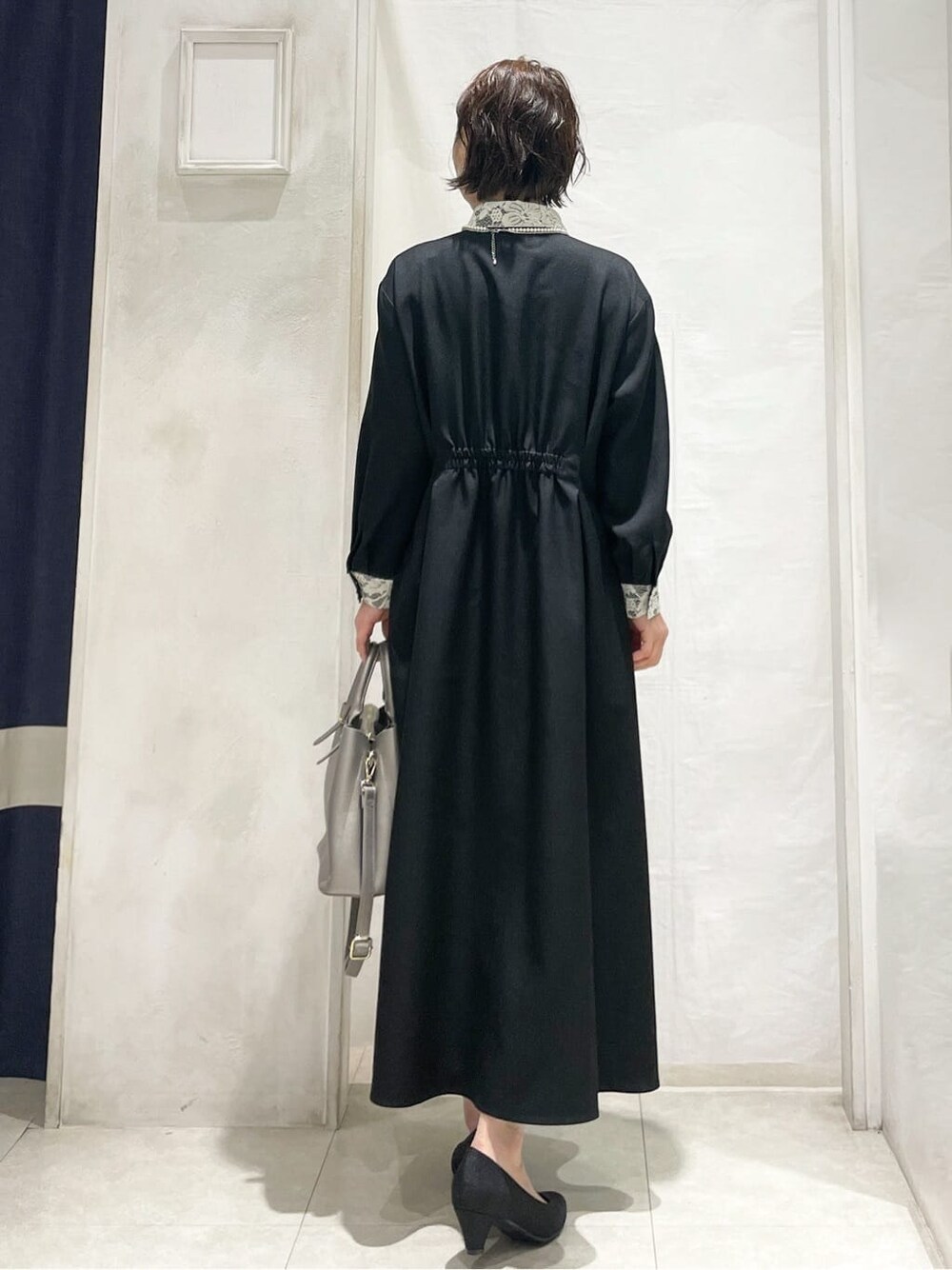 ブラック系のワンピース、シルバー系のトートバッグ、ブラック系のパンプスを着用したレディースの冬コーディネートの3枚目の写真