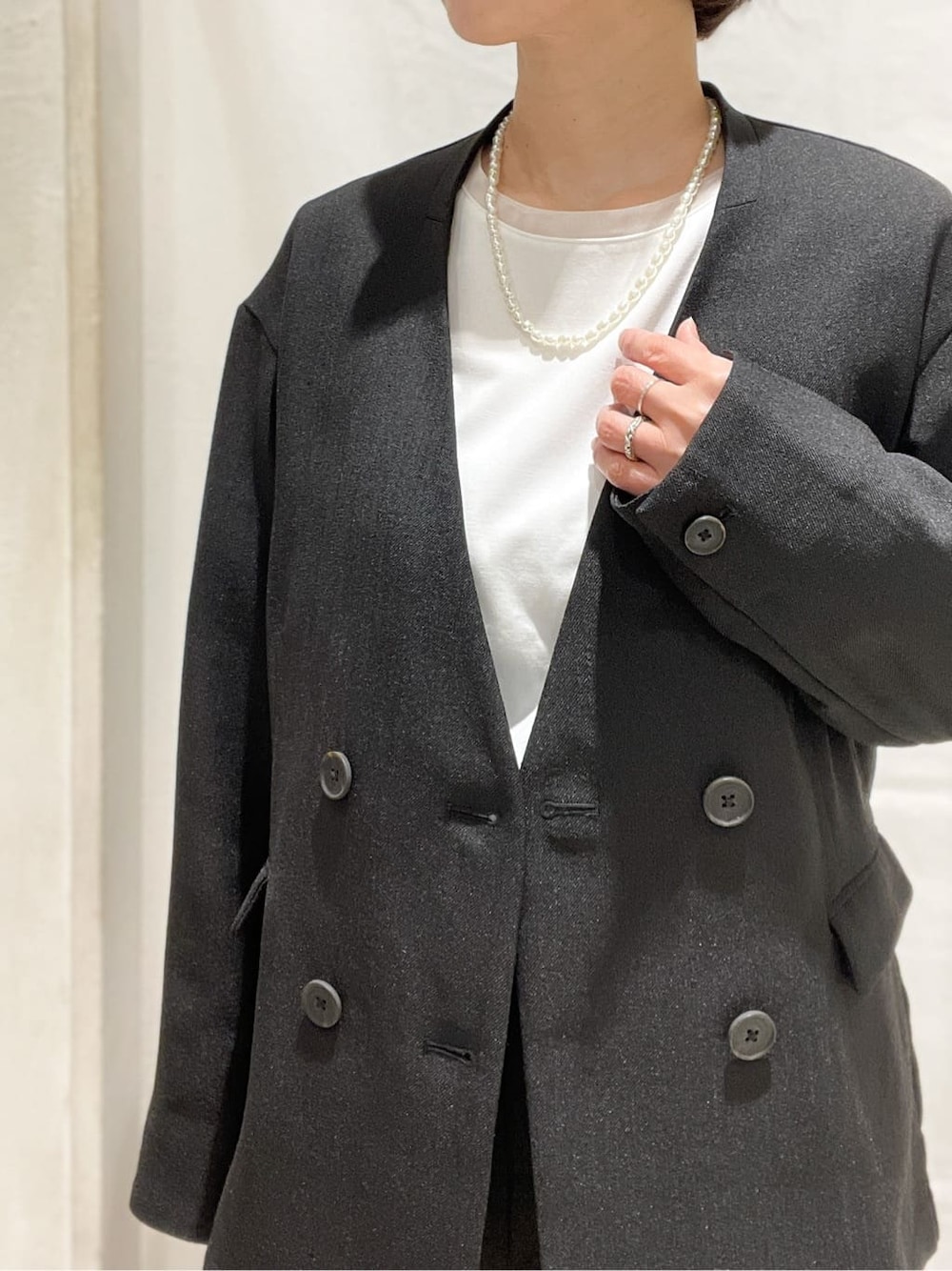 ブラウン系のパンプス、グレー系のショルダーバッグ、ブラック系のノーカラージャケットを着用したレディースの春コーディネートの5枚目の写真