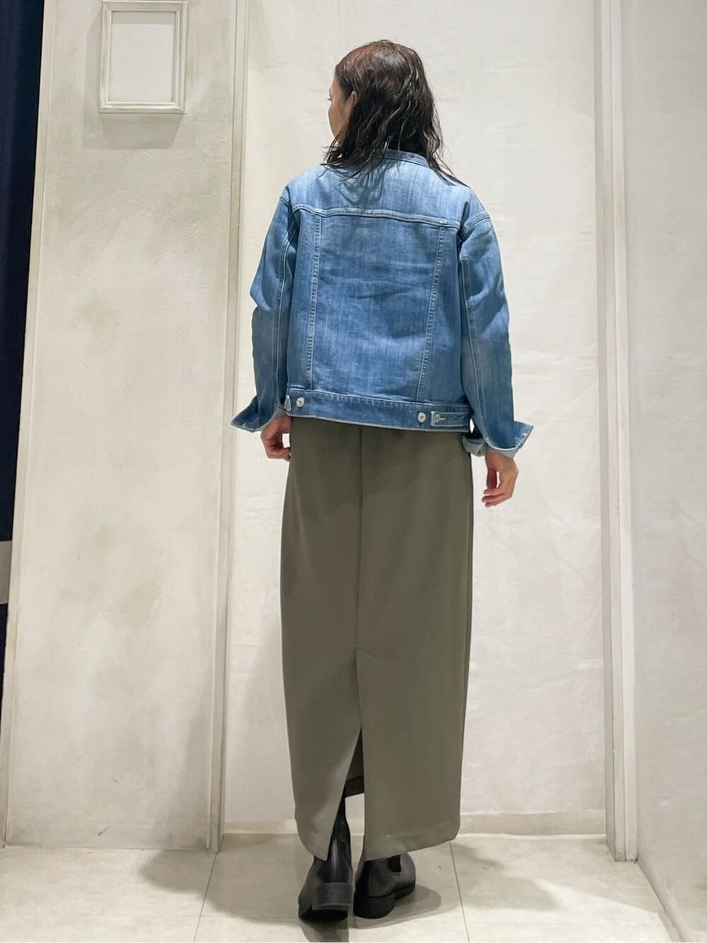 ブルー系のデニムジャケット、グレー系のニット/セーター、ブラウン系のスカートを着用したレディースの冬コーディネートの4枚目の写真